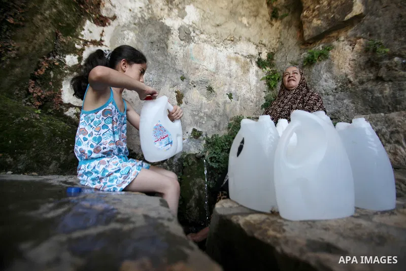 A Palestinian girl fills a jerrican with spring water on June 27, 2016 in Salfit, north of Ramallah, where some of the West Bank village's inhabitants have been without water for days. Tens of thousands of Palestinians i...