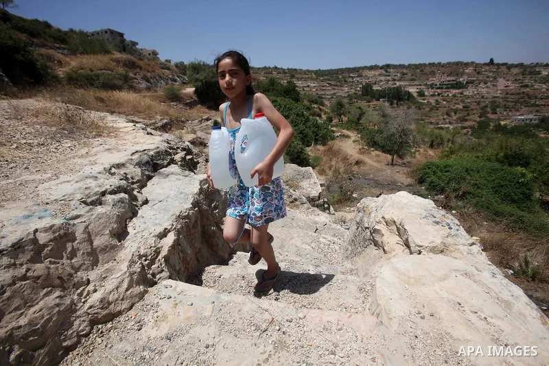 A Palestinian girl carries a jerrican filled with spring water on June 27, 2016 in Salfit, north of Ramallah, where some of the West Bank village's inhabitants have been without water for days. Tens of thousands of Pales...