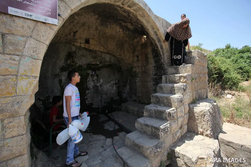 A Palestinian boy carries a jerrican filled with spring water on June 27, 2016 in Salfit, north of Ramallah, where some of the West Bank village's inhabitants have been without water for days. Tens of thousands of Palest...