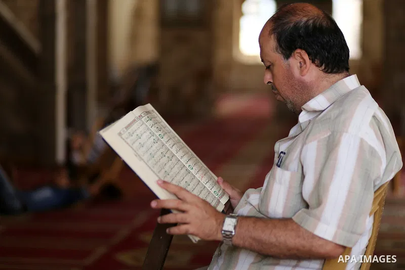A Palestinian man reads the Koran, Islam's holy book, at Sayed Hashim Mosque, during the Muslim holy month of Ramadan, in Gaza city on June 27, 2016. Ramadan is sacred to Muslims because it is during that month that trad...