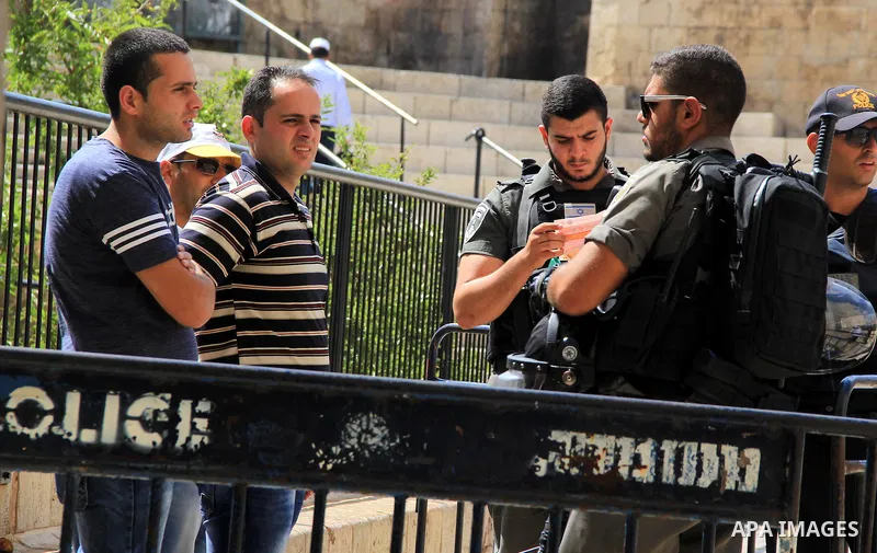 Israeli policemen checks the IDs of Palestinian youths at Al-Aqsa Mosque compound in Jerusalem's old city, on June 28, 2016. An Israeli police spokesman said on Tuesday that the compound would be closed to visitors, incl...