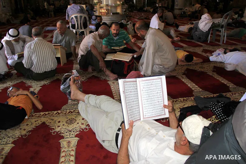 Palestinian men read the Koran, Islam's holy book, at al-Aqsa mosque during the holy month of Ramadan, in Jerusalem's old city, on June 28, 2016. An Israeli police spokesman said on Tuesday that the compound would be clo...