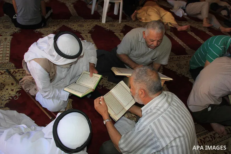Palestinian men read the Koran, Islam's holy book, at al-Aqsa mosque during the holy month of Ramadan, in Jerusalem's old city, on June 28, 2016. An Israeli police spokesman said on Tuesday that the compound would be clo...