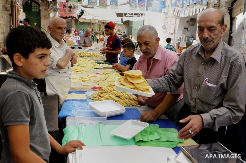 Palestinians shop at a market during the holy month of Ramadan in the West Bank city of Hebron, on June 28, 2016. Photo by Wisam Hashlamoun