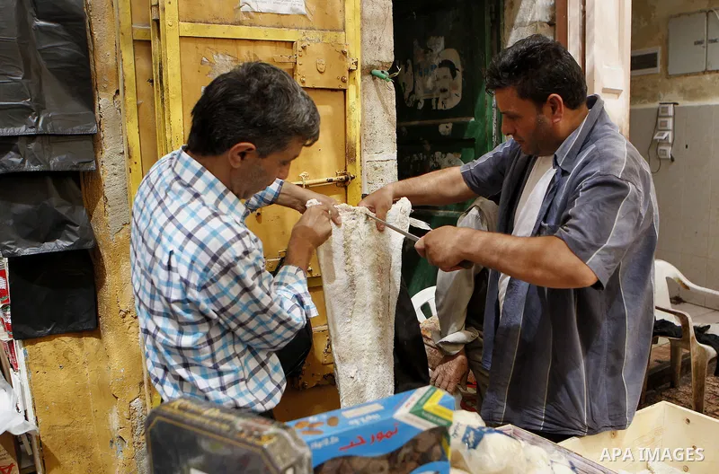 Palestinians shop at a market during the holy month of Ramadan in the West Bank city of Hebron, on June 28, 2016. Photo by Wisam Hashlamoun