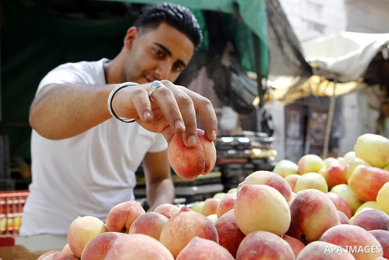 Palestinians shop at a market during the holy month of Ramadan in the West Bank city of Hebron, on June 28, 2016. Photo by Wisam Hashlamoun