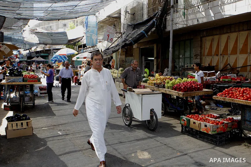 Palestinians shop at a market during the holy month of Ramadan in the West Bank city of Hebron, on June 28, 2016. Photo by Wisam Hashlamoun