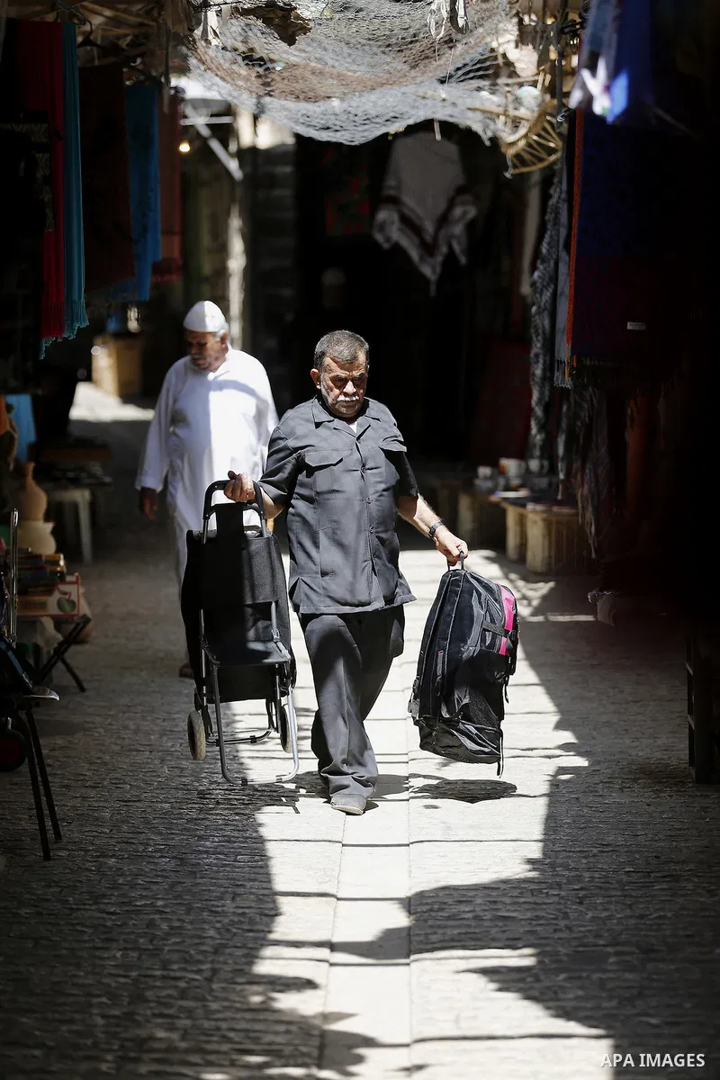 Palestinians shop at a market during the holy month of Ramadan in the West Bank city of Hebron, on June 28, 2016. Photo by Wisam Hashlamoun