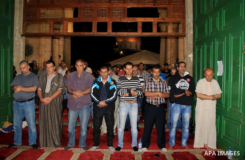 Palestinian Muslim worshippers perform "Taraweeh", nightly prayer of the month of Ramadan, in front of the Dome of the Rock mosque, in Jerusalem's old city on June 28, 2016. Ramadan is sacred to Muslims because it is dur...
