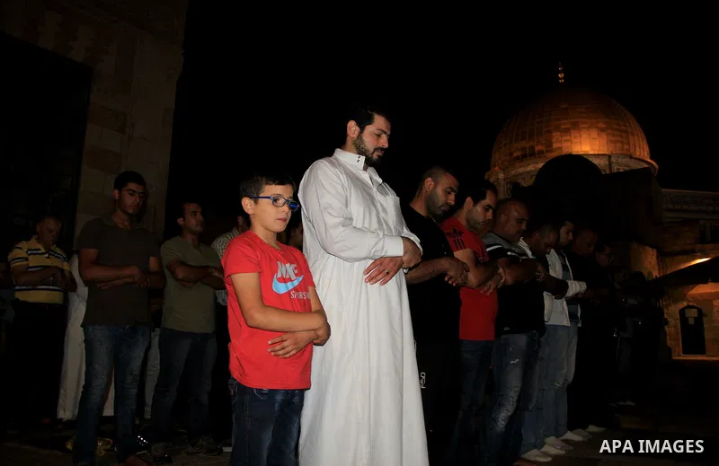 Palestinian Muslim worshippers perform "Taraweeh", nightly prayer of the month of Ramadan, in front of the Dome of the Rock mosque, in Jerusalem's old city on June 28, 2016. Ramadan is sacred to Muslims because it is dur...