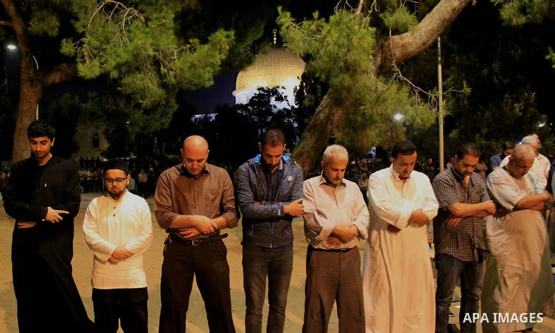 Palestinian Muslim worshippers perform "Taraweeh", nightly prayer of the month of Ramadan, in front of the Dome of the Rock mosque, in Jerusalem's old city on June 28, 2016. Ramadan is sacred to Muslims because it is dur...