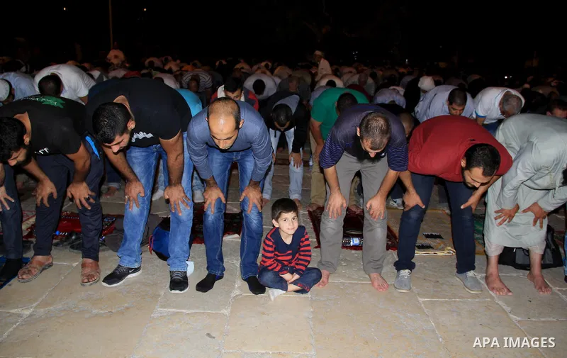 Palestinian Muslim worshippers perform "Taraweeh", nightly prayer of the month of Ramadan, in front of the Dome of the Rock mosque, in Jerusalem's old city on June 28, 2016. Ramadan is sacred to Muslims because it is dur...