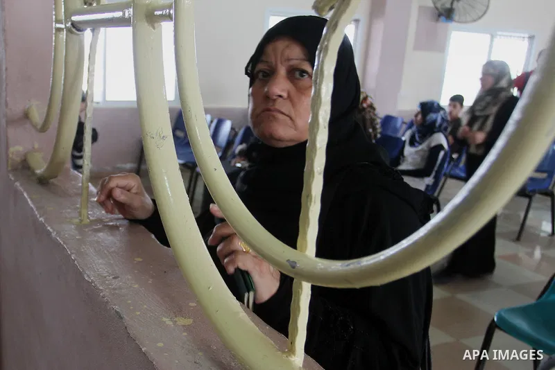 A woman looks through a window as she waits for a travel permit to cross into Egypt through the Rafah border crossing after it was opened by Egyptian authorities for five days, in the southern Gaza Strip June 29, 2016. P...