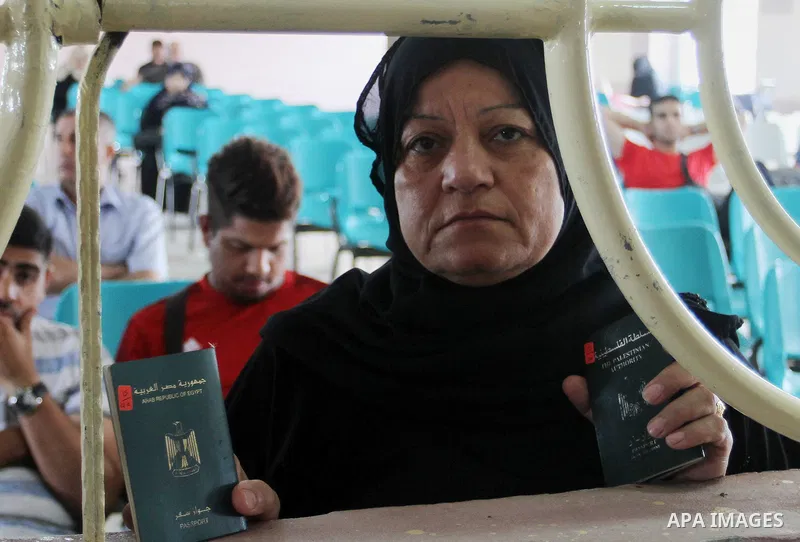 A woman looks through a window as she waits for a travel permit to cross into Egypt through the Rafah border crossing after it was opened by Egyptian authorities for five days, in the southern Gaza Strip June 29, 2016. P...