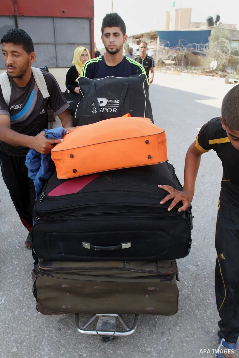 Palestinians pull their luggage as they wait for a travel permit to cross into Egypt through the Rafah border crossing after it was opened by Egyptian authorities for five days, in the southern Gaza Strip June 29, 2016....