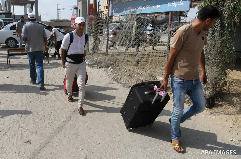 Palestinians pull their luggage as they wait for a travel permit to cross into Egypt through the Rafah border crossing after it was opened by Egyptian authorities for five days, in the southern Gaza Strip June 29, 2016....