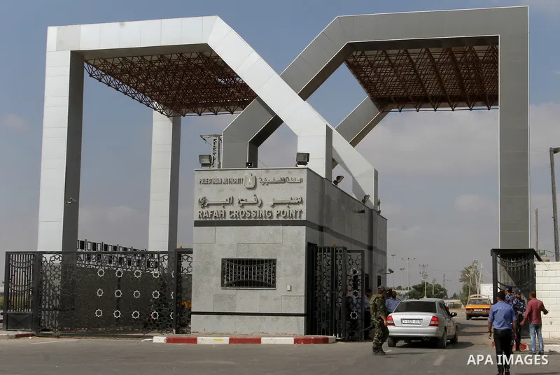 Security stand guard as Palestinians residing in the Gaza Strip wait for a travel permit to cross into Egypt through the Rafah border crossing after it was opened by Egyptian authorities for five days, in the southern Ga...