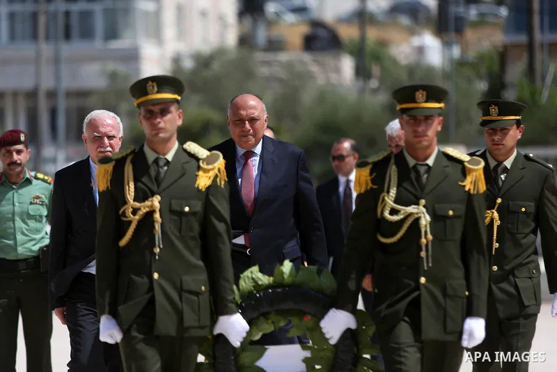 Egyptian Foreign Minister Sameh Shoukry prepares to lay a wreath of flowers on the tomb of late Palestinian leader Yasser Arafat during a visit to the Palestinian authority headquarters in the West Bank city of Ramallah...