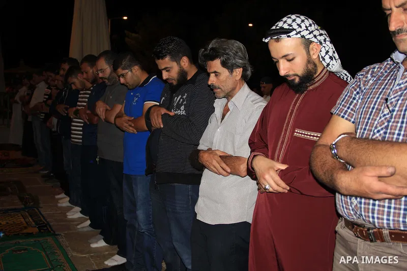 Palestinian Muslim worshippers perform "Taraweeh", nightly prayer of the month of Ramadan, in front of the Dome of the Rock mosque, in Jerusalem's old city on June 29, 2016. Ramadan is sacred to Muslims because it is dur...