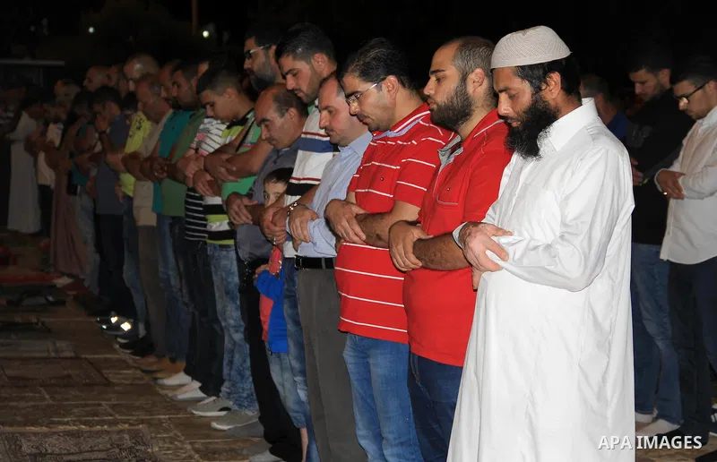 Palestinian Muslim worshippers perform "Taraweeh", nightly prayer of the month of Ramadan, in front of the Dome of the Rock mosque, in Jerusalem's old city on June 29, 2016. Ramadan is sacred to Muslims because it is dur...