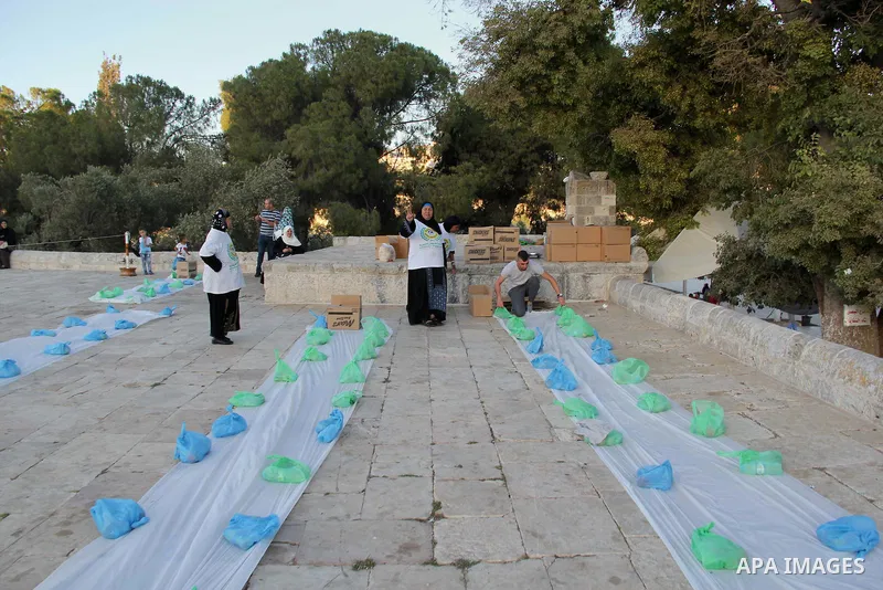 Palestinian muslims prepare to break their fast during the holy fasting month of Ramadan in front of the Dome of the Rock mosque at the al-Aqsa mosque compound, in Jerusalem's old city on June 29, 2016. Ramadan is sacred...