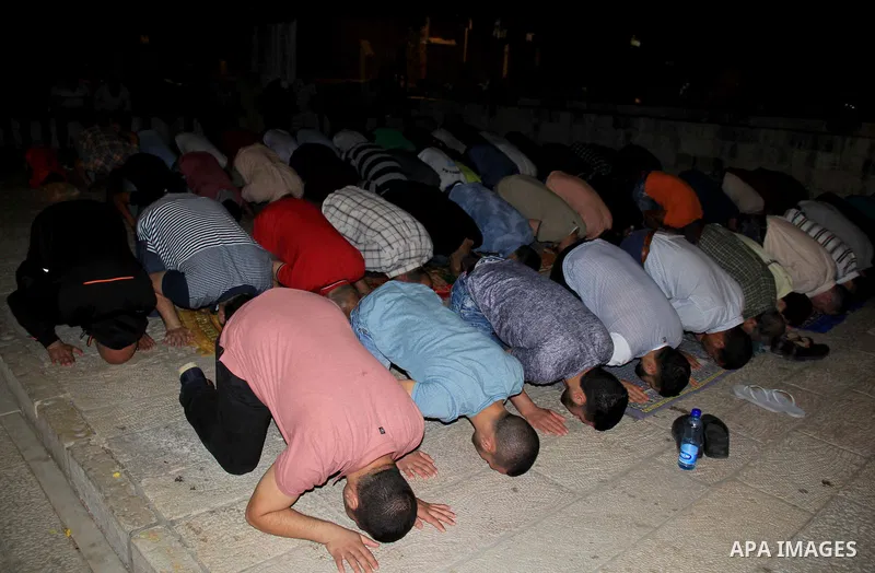 Palestinian Muslim worshippers perform "Taraweeh", nightly prayer of the month of Ramadan, in front of the Dome of the Rock mosque, in Jerusalem's old city on June 29, 2016. Ramadan is sacred to Muslims because it is dur...