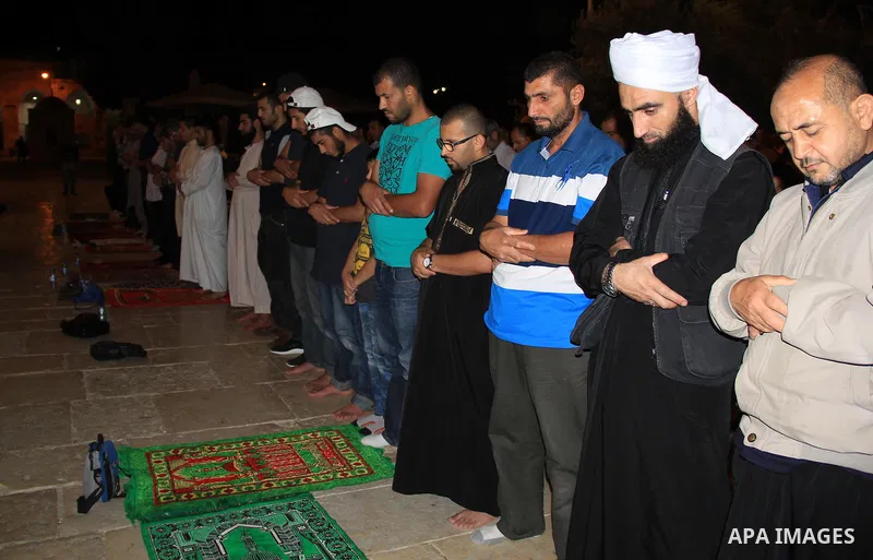 Palestinian Muslim worshippers perform "Taraweeh", nightly prayer of the month of Ramadan, in front of the Dome of the Rock mosque, in Jerusalem's old city on June 29, 2016. Ramadan is sacred to Muslims because it is dur...