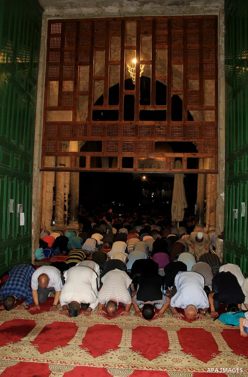 Palestinian Muslim worshippers perform "Taraweeh", nightly prayer of the month of Ramadan, in front of the Dome of the Rock mosque, in Jerusalem's old city on June 29, 2016. Ramadan is sacred to Muslims because it is dur...