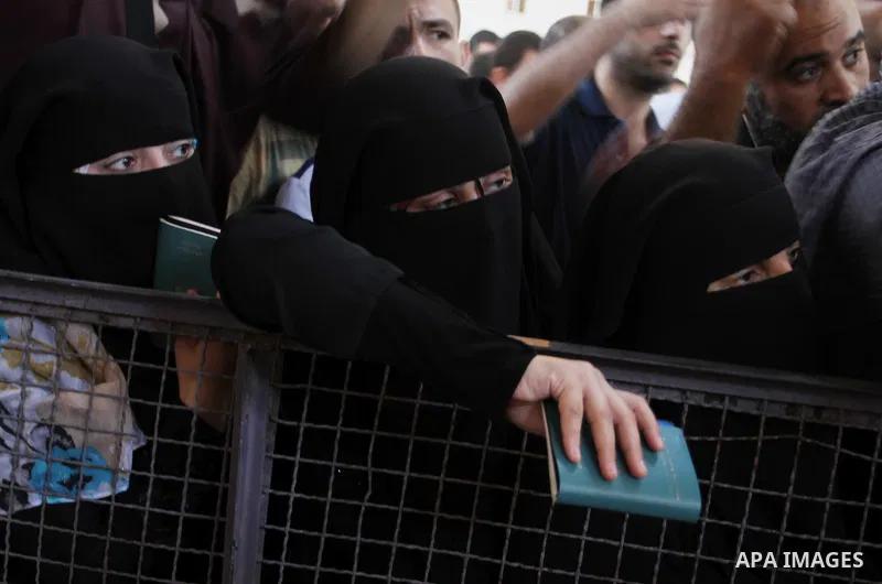 Palestinians wait for a travel permit to cross into Egypt through the Rafah border crossing after it was opened by Egyptian authorities for five days, in the southern Gaza Strip June 30, 2016. Photo by Abed Rahim Khatib