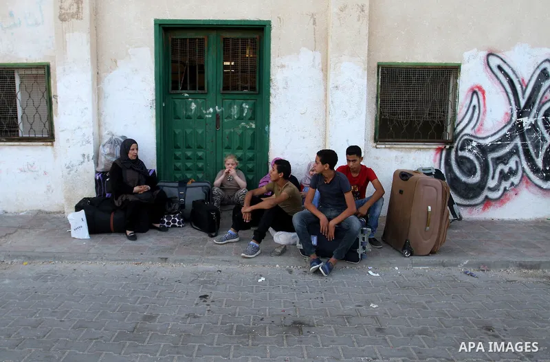 Palestinians wait for a travel permit to cross into Egypt through the Rafah border crossing after it was opened by Egyptian authorities for five days, in the southern Gaza Strip June 30, 2016. Photo by Abed Rahim Khatib