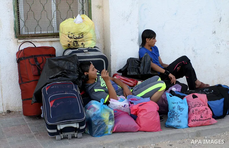 Palestinians wait for a travel permit to cross into Egypt through the Rafah border crossing after it was opened by Egyptian authorities for five days, in the southern Gaza Strip June 30, 2016. Photo by Abed Rahim Khatib
