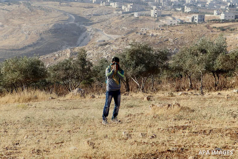 Palestinians run for a cover from teargas canisters fired by Israeli border police near a barbed-wire gate part of the controversial Israeli separation fence between the West Bank town of Bethlehem and Jerusalem, after a...