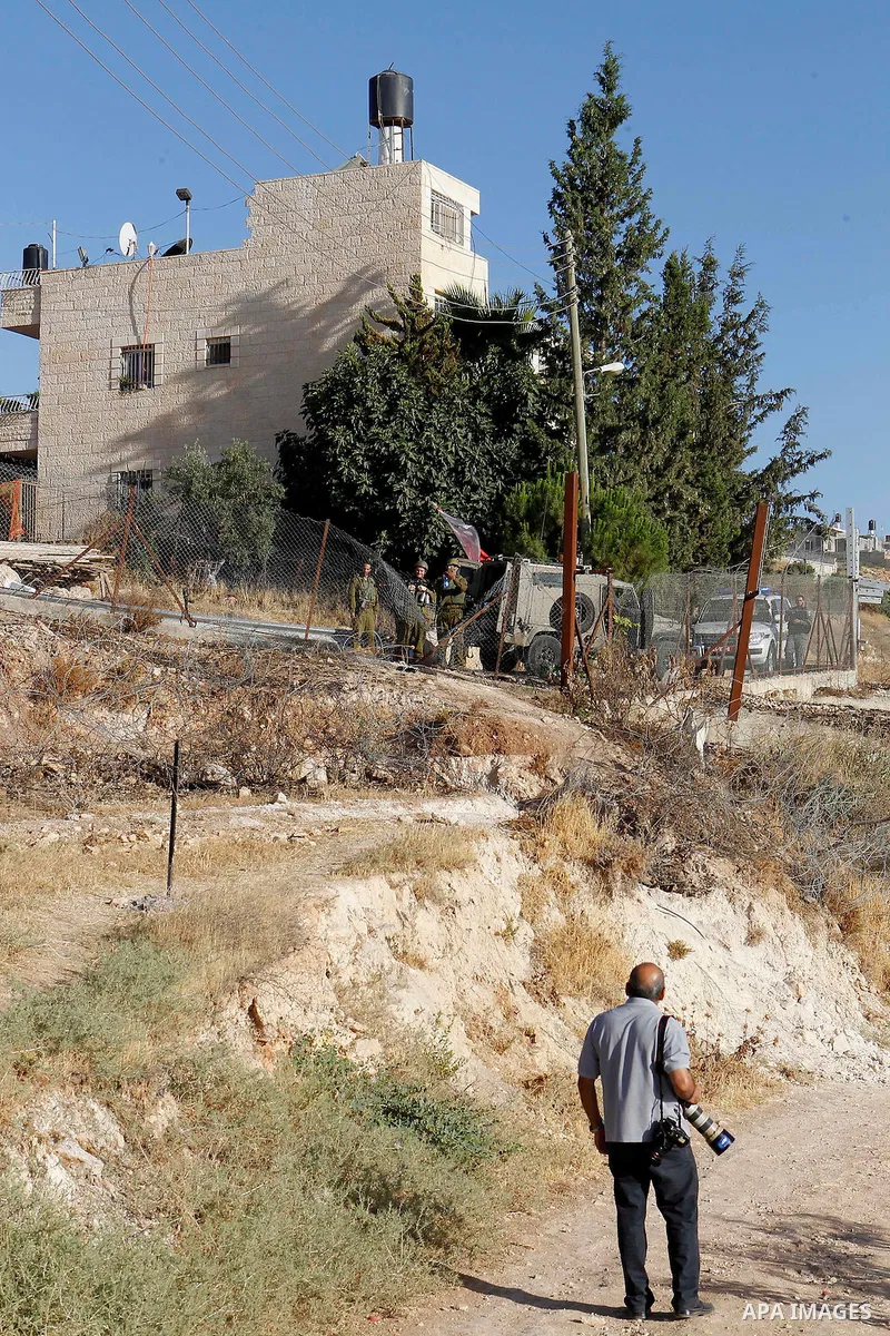 A Palestinian photographer reacts as Israeli border police fire teargas canisters near a barbed-wire gate part of the controversial Israeli separation fence between the West Bank town of Bethlehem and Jerusalem, after an...