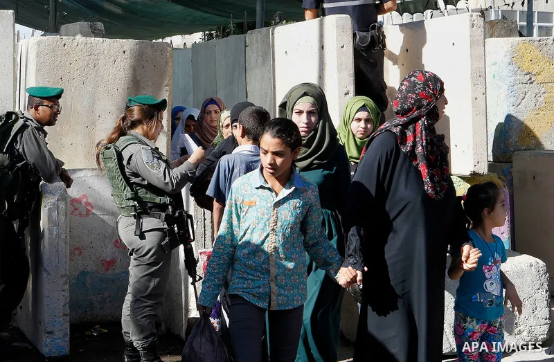 Israeli border police check Palestinians West Bank identity card at an Israeli checkpoint between the town of Bethlehem and Jerusalem, as he heads to Jerusalem's Al-Aqsa Mosque compound on the forth and last Friday of th...