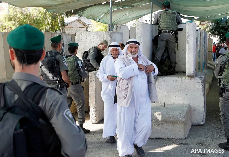Israeli border police check Palestinians West Bank identity card at an Israeli checkpoint between the town of Bethlehem and Jerusalem, as he heads to Jerusalem's Al-Aqsa Mosque compound on the forth and last Friday of th...