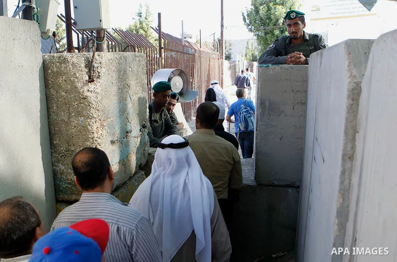 Israeli border police check Palestinians West Bank identity card at an Israeli checkpoint between the town of Bethlehem and Jerusalem, as he heads to Jerusalem's Al-Aqsa Mosque compound on the forth and last Friday of th...