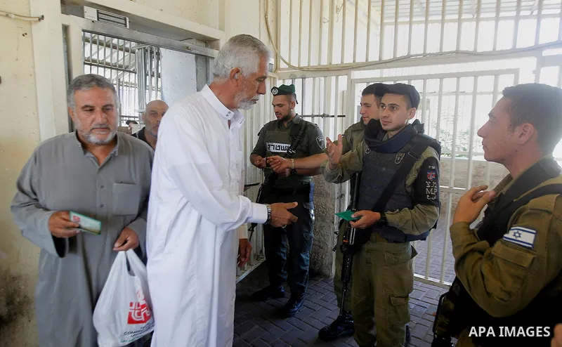 Israeli border police check Palestinians West Bank identity card at an Israeli checkpoint between the town of Bethlehem and Jerusalem, as he heads to Jerusalem's Al-Aqsa Mosque compound on the forth and last Friday of th...
