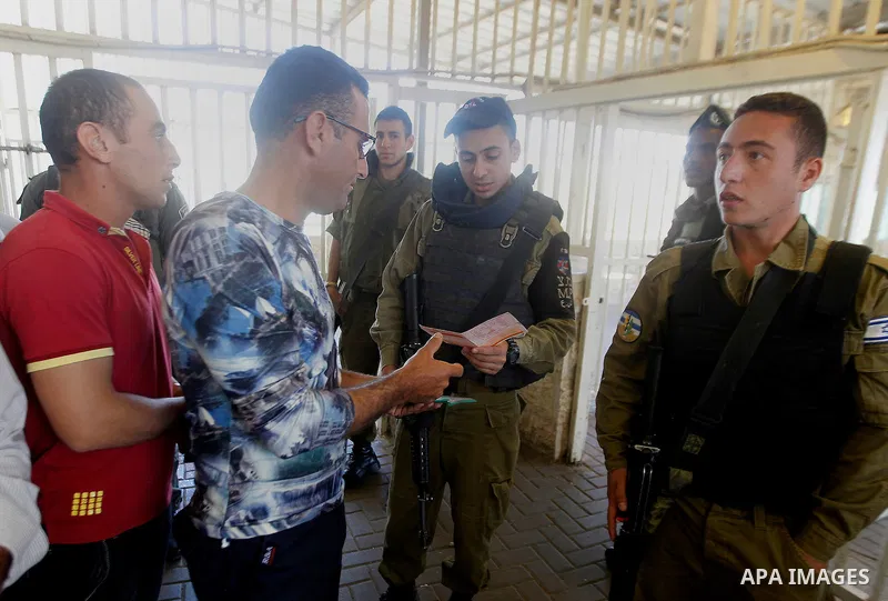 Israeli border police check Palestinians West Bank identity card at an Israeli checkpoint between the town of Bethlehem and Jerusalem, as he heads to Jerusalem's Al-Aqsa Mosque compound on the forth and last Friday of th...