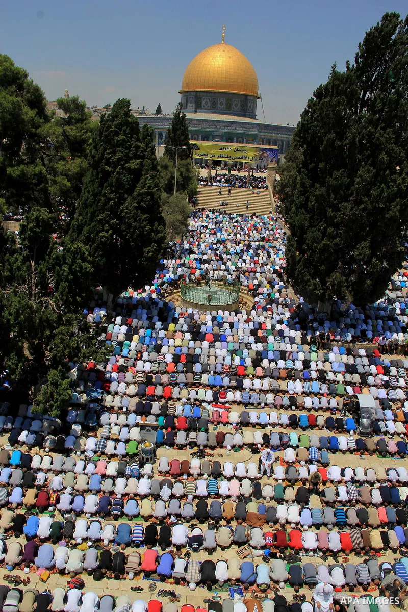 Palestinian men pray outside the Dome of the Rock in Jerusalem's Al-Aqsa mosque compound during the last Friday prayers of the holy Muslim fasting month of Ramadan on July 1, 2016. Photo by Mahfouz Abu Turk