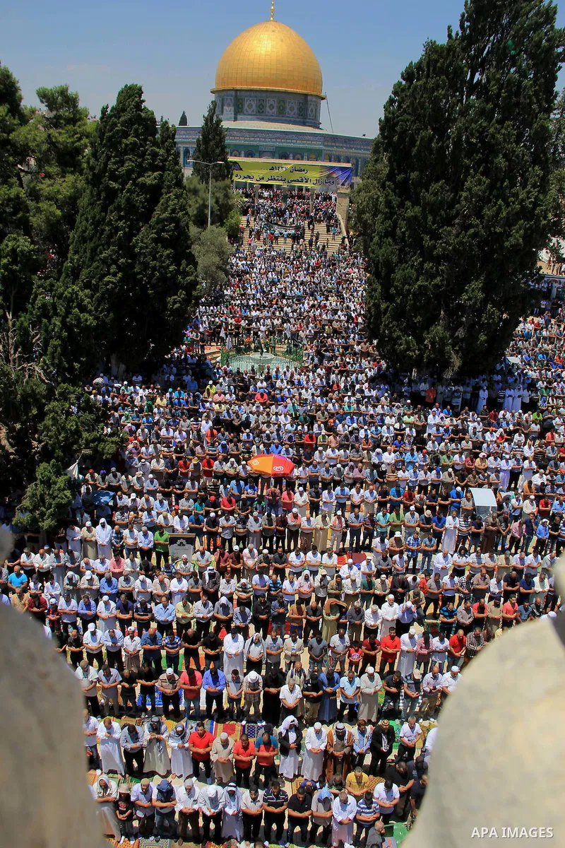 Palestinian men pray outside the Dome of the Rock in Jerusalem's Al-Aqsa mosque compound during the last Friday prayers of the holy Muslim fasting month of Ramadan on July 1, 2016. Photo by Mahfouz Abu Turk