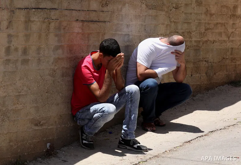 Palestinian protesters cover their faces from a tear gas fired by Israeli security forces during clashes following a demonstration against the expropriation of Palestinian land by Israel on July 01, 2016 in the village o...