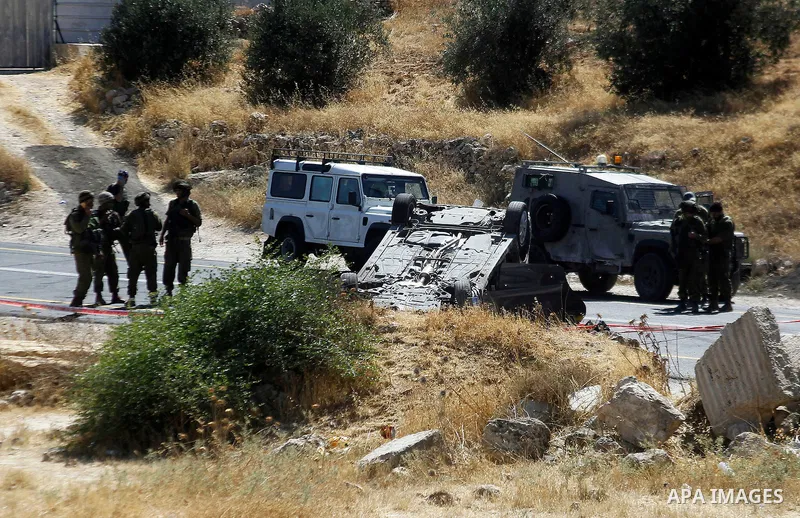 Israeli security forces gather at the scene following a shooting on an Israeli car near the West Bank city of Hebron July 1, 2016. Photo by Wisam Hashlamoun