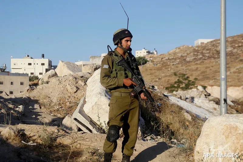 Israeli soldiers close a barrier blocking the road at a southern entrance of Hebron on July 2, 2016, after Israeli troops locked down the occupied West Bank city following Palestinian attacks. Israeli forces locked gates...