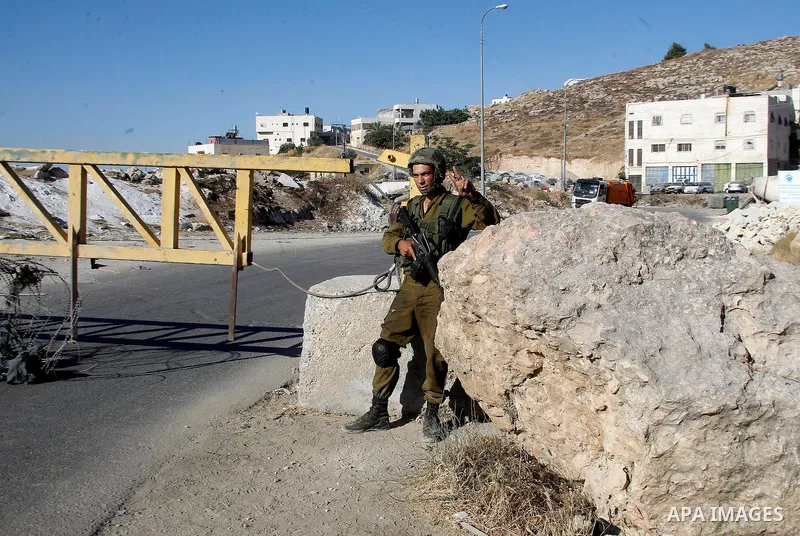 Israeli soldiers close a barrier blocking the road at a southern entrance of Hebron on July 2, 2016, after Israeli troops locked down the occupied West Bank city following Palestinian attacks. Israeli forces locked gates...