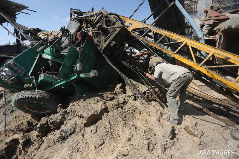 A Palestinian man looks at the damage following an Israeli air strike on a workshop in Gaza City on July 2, 2016. Israeli air strikes hit four sites in the Gaza Strip, causing damage but no injuries, officials said, afte...