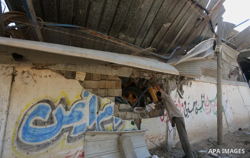 A Palestinian man looks at the damage following an Israeli air strike on a workshop in Gaza City on July 2, 2016. Israeli air strikes hit four sites in the Gaza Strip, causing damage but no injuries, officials said, afte...