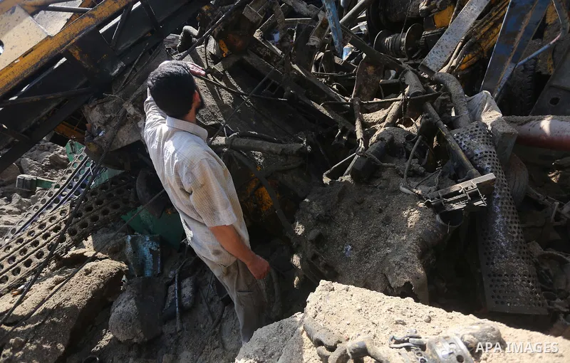 A Palestinian man looks at the damage following an Israeli air strike on a workshop in Gaza City on July 2, 2016. Israeli air strikes hit four sites in the Gaza Strip, causing damage but no injuries, officials said, afte...