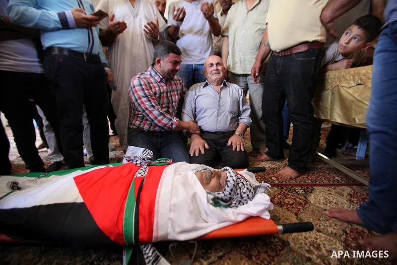 Mourners pray on the body of Palestinian Tayseer Habash, who died from tear gas fired by Israeli security forces during clashes, during his funeral on July 2, 2016 in the West Bank city of Nablus. Habash, 63, died on Jul...