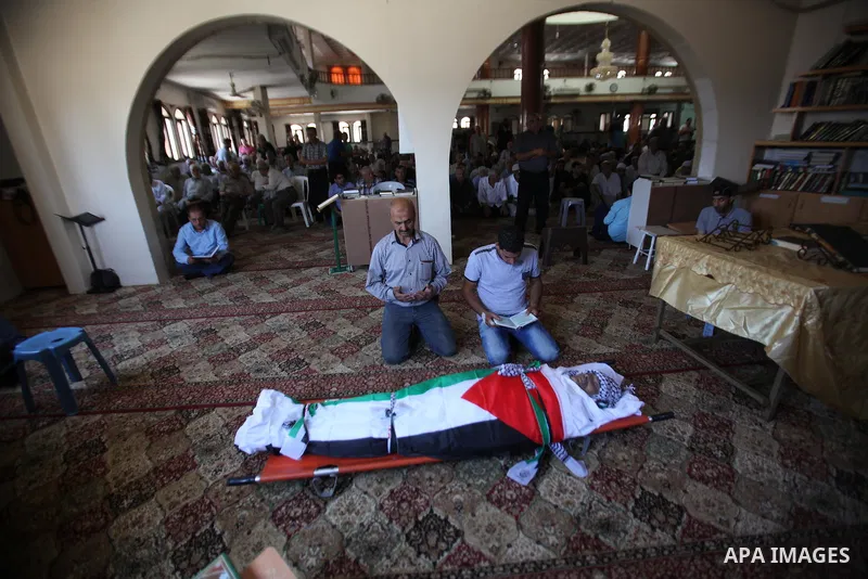 Mourners pray on the body of Palestinian Tayseer Habash, who died from tear gas fired by Israeli security forces during clashes, during his funeral on July 2, 2016 in the West Bank city of Nablus. Habash, 63, died on Jul...