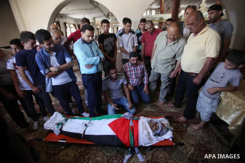 Mourners pray on the body of Palestinian Tayseer Habash, who died from tear gas fired by Israeli security forces during clashes, during his funeral on July 2, 2016 in the West Bank city of Nablus. Habash, 63, died on Jul...